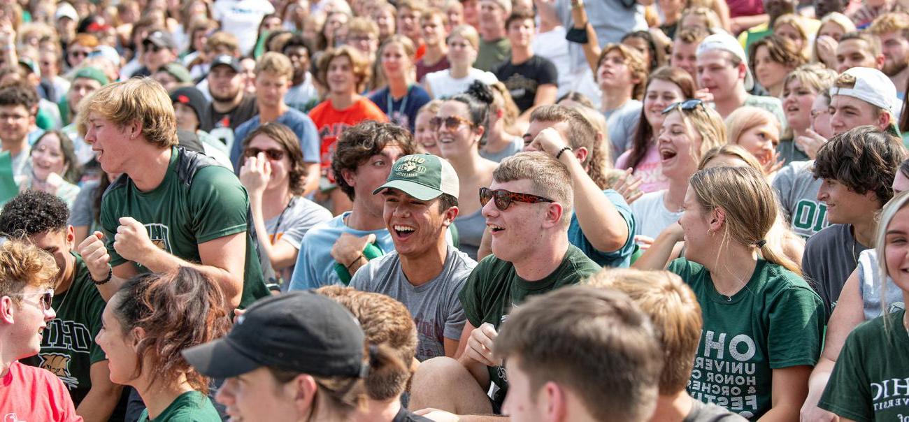 A group of bet8九州登录入口 students laugh 和 smile together after sitting in the st和s of a stadium